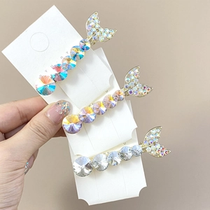 Detail showing three rhinestone mermaid tail hair clips in iridescent, purple and clear colors