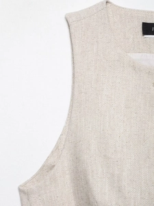 Detailed close-up of beige linen vest shoulder showing premium stitching and fabric texture