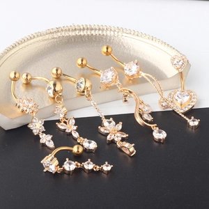 Detail view of 7-piece gold belly ring set featuring varied cubic zirconia charms