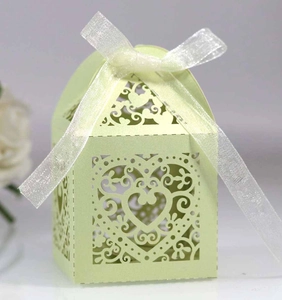 Detail of laser-cut heart pattern on mint green wedding favors box with ribbon bow