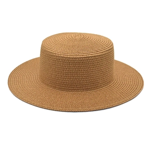Close-up of finely woven texture on a minimalist flat top straw sun hat in light brown