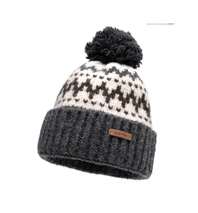 Detailed view of grey knit beanie featuring pom-pom and leather Lure Plus label