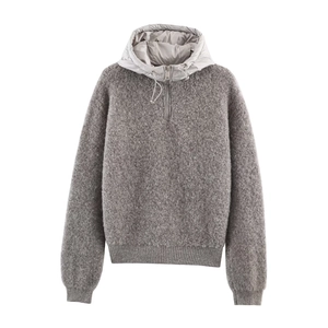 Détail d'un sweat à capuche gris en maille avec design patchwork, cordon et demi-fermeture