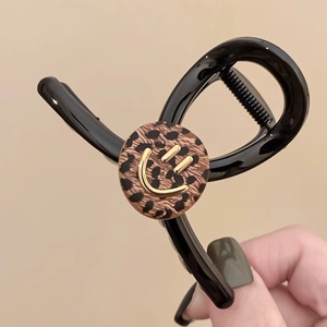 Elegant medium hair claw clip with black frame and leopard print smiley face accent