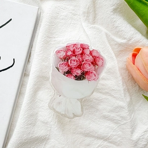 Close-up of pink rose bouquet acrylic phone socket grip on white wrinkled fabric