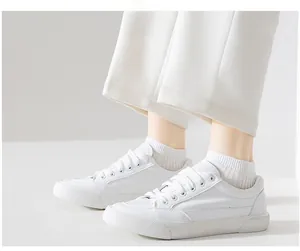 Close-up of white vertical striped cotton ankle socks paired with casual canvas sneakers