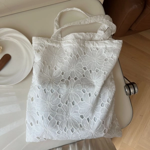 Minimalist white cotton eyelet embroidery tote bag with delicate floral lace patterns