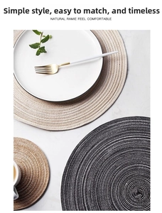 Detail of hand-woven round ramie placemats with fine spiral texture in beige and grey