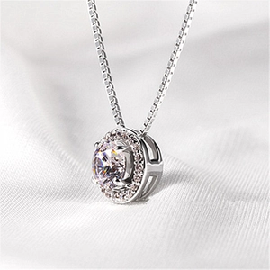 Macro detail of 2 carat round cubic zirconia pendant with pavé halo on silver chain