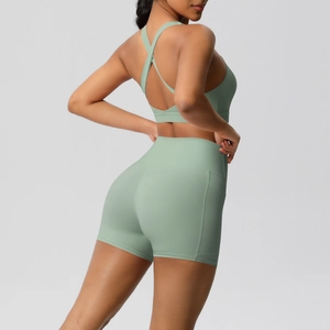 Detail view of sage green yoga set showing cross back sports bra and high waist side pockets