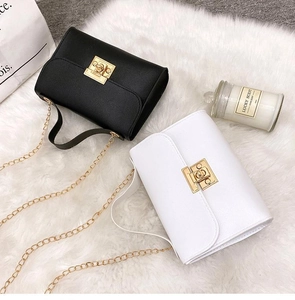 Flat lay of small chain square bags in black and white leather with gold hardware
