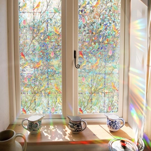 Detailed view of the colorful window film showcasing vibrant tree and bird patterns with rainbows.