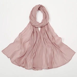 Makroaufnahme von rosa glänzendem Chiffonschal mit eleganter Plisseestruktur auf Weiß