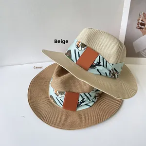 Détail de chapeaux en paille avec foulard en soie à motif sirène et ornements en cuir chic