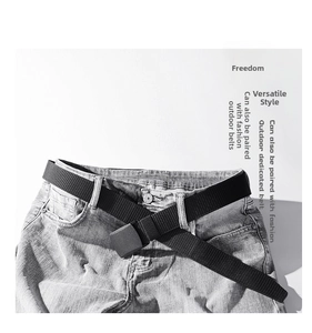 Detail of black tactical nylon belt with matte buckle on grey distressed jeans