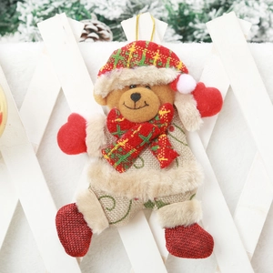 Detail of Christmas bear plush pendant with plaid hat and fur trim on white fence