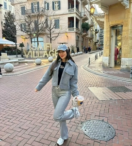 Outdoor street view of a cropped grey wool jacket styled with a dark navy baseball cap