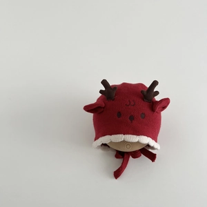 Detail of red knit baby winter hat with cute 3D reindeer antlers and chin straps