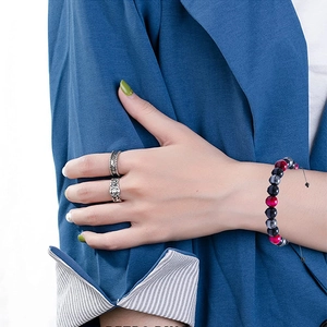 Close-up of retro silver rings and adjustable three-color beaded bracelet on hand