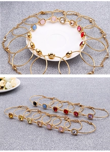 Detail of 18k gold plated bracelets featuring colorful square-cut zircon gemstones