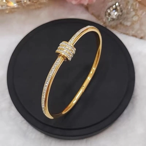 Macro shot of gold-plated bangle featuring triple rings set with sparkling pavé zircons