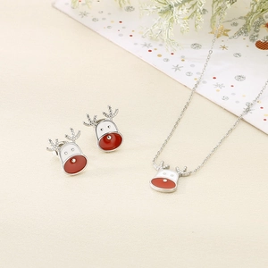 Macro shot of silver stainless steel reindeer necklace and stud earrings with red enamel