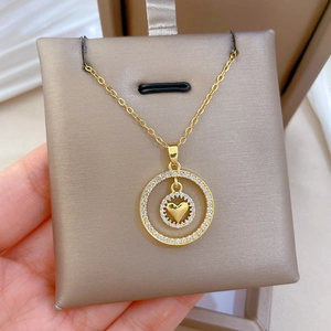 Dettaglio macro della collana con ciondolo a cuore a doppio anello e zirconi lucidi
