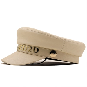 Dettaglio del cappello ottagonale in ecopelle beige con logo JED2D dorato e trama liscia
