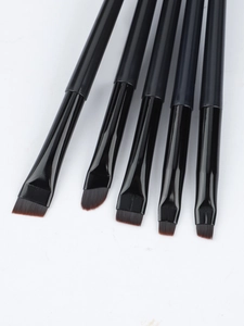 Macro detail of 5-piece angled eyeliner and eyebrow brush set with synthetic bristles