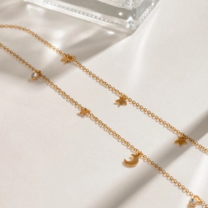 Close-up of gold star and moon necklace pendants with sparkling zircon stone inlay