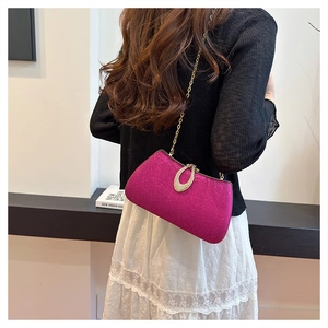 Detail of rose red evening clutch bag with golden chain and diamond ring buckle