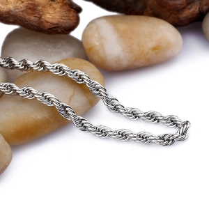 Macro shot of 3mm silver twisted rope chain with driftwood and pebbles on white background