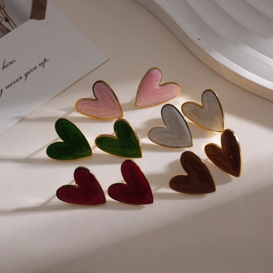 Macro detail of heart-shaped earrings with colorful enamel marble texture and gold frames