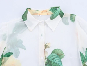 Détail du col d'une chemise élégante avec imprimé roses jaunes et feuilles vertes