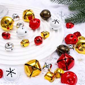 Colorful Christmas metal bells set in gold, red, and white on a decorative tray