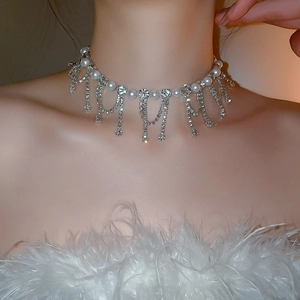 Detailed close-up of a luxury pearl choker with sparkling diamond tassel fringes