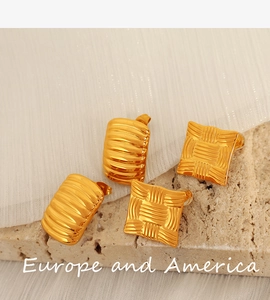 Detail of golden geometric stud earrings with stripe and weave texture on stone base
