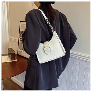 Detail of white leather crescent bag featuring woven edges and silver chain strap