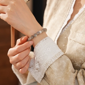 Close-up of grey labradorite beaded bracelet with silver spacers on a female wrist