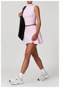 Detailansicht des rosa zweiteiligen Yoga-Sets mit engem Crop-Top und plissiertem Minirock