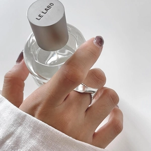 Minimalist 925 sterling silver twisted ring with small bead accents on hand