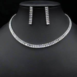 Detailed view of silver tennis necklace and earrings set with zircon stones on a model
