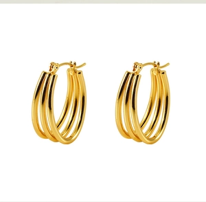Detail of 18k gold triple hoop earrings with a secure hinged closure mechanism