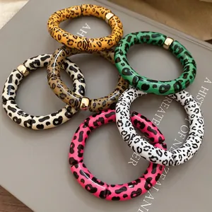 Chic leopard print resin tube bracelets with gold accents on a stylish book cover