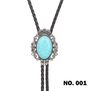 Detail view of bolo tie showing crown ornament and blue turquoise stone in zinc alloy base