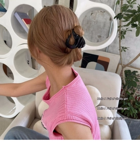Pince à cheveux noire brillante tenant une queue de cheval sur un mannequin femme