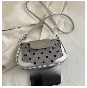 Gros plan sur le sac à bandoulière à pois montrant la taille par rapport au téléphone