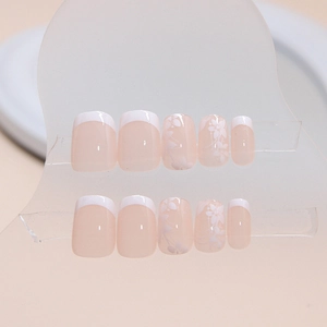 Short French press-on nails with white flower patterns on translucent pink base
