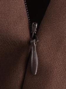 Close-up of a concealed brown zipper on high-quality textured vintage suit fabric
