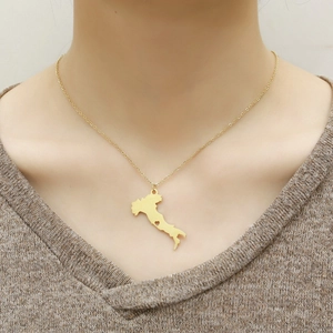 Close-up of a gold Italy map necklace featuring a small heart cutout on a fine chain